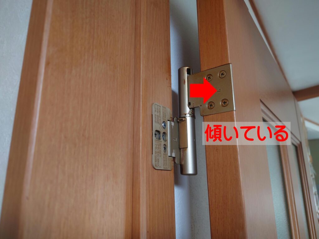 傾いて摩耗しているトステム製室内ドアの丁番