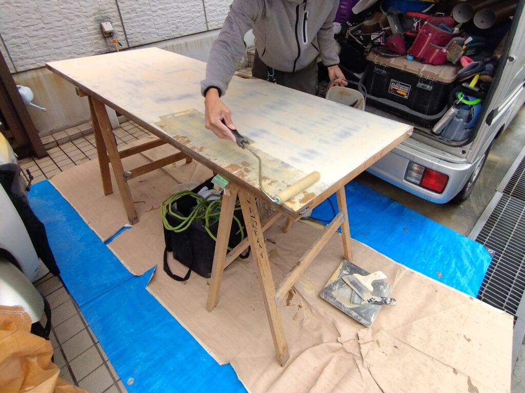 ダイノックシート施工前に室内ドア表面へプライマーを塗布している様子