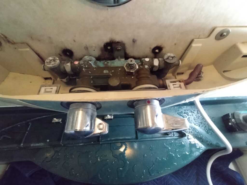 カウンター上部のカバーを外し、ユニット一体型混合栓を確認している様子。